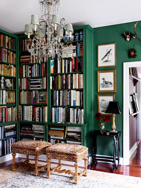 Emerald green built-in bookshelves home library with chandelier and library stools ottomans