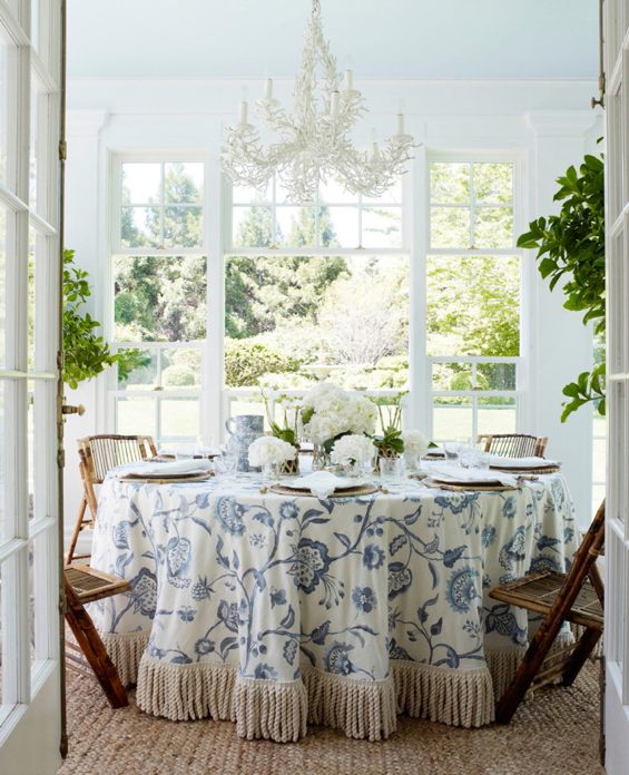 Aerin Lauder Dining Room Blue and White Skirted Table Bullion Fringe White Coral Chandelier Bamboo Folding Chairs
