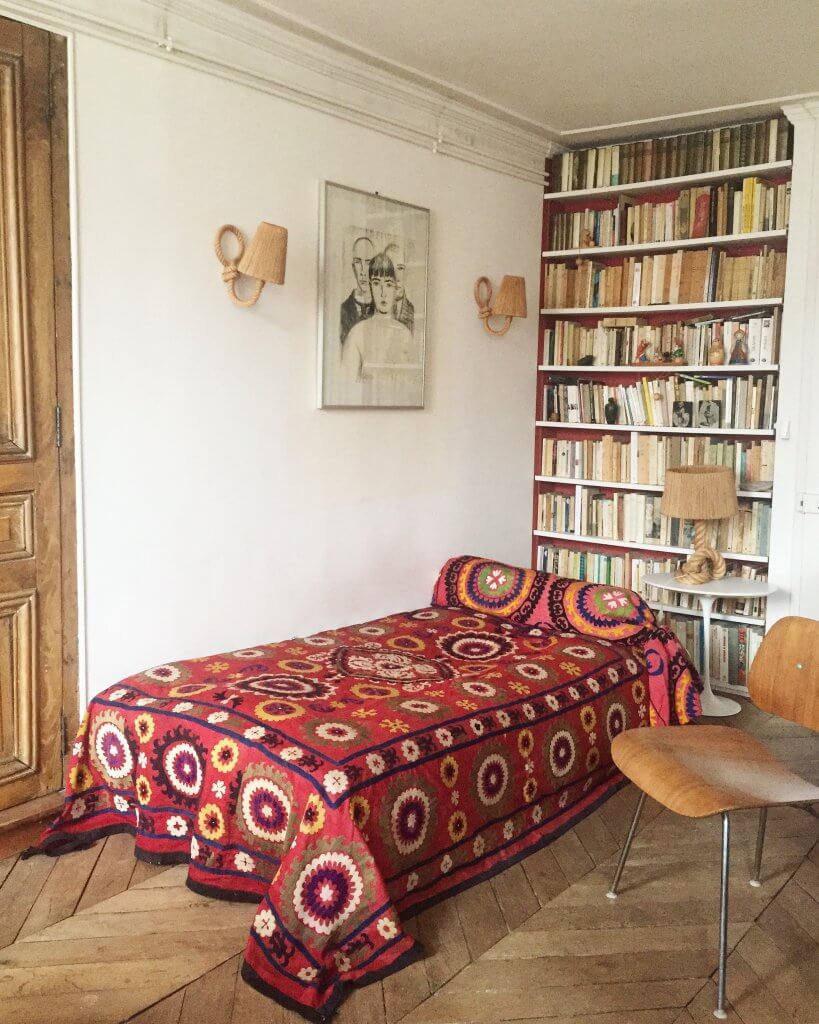 Vintage red suzani bedspread Paris apartment wood floors