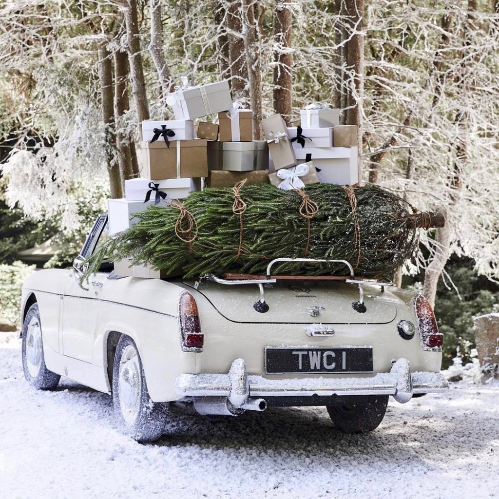 Vintage White Convertible Car with Christmas Tree and Presents in the Snow
