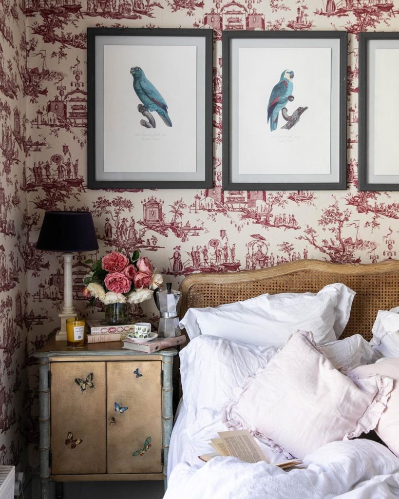 Skye McAlpine Bedroom with Red and White Toile Wallpaper Cane Headboard Parrot Bird Art Prints