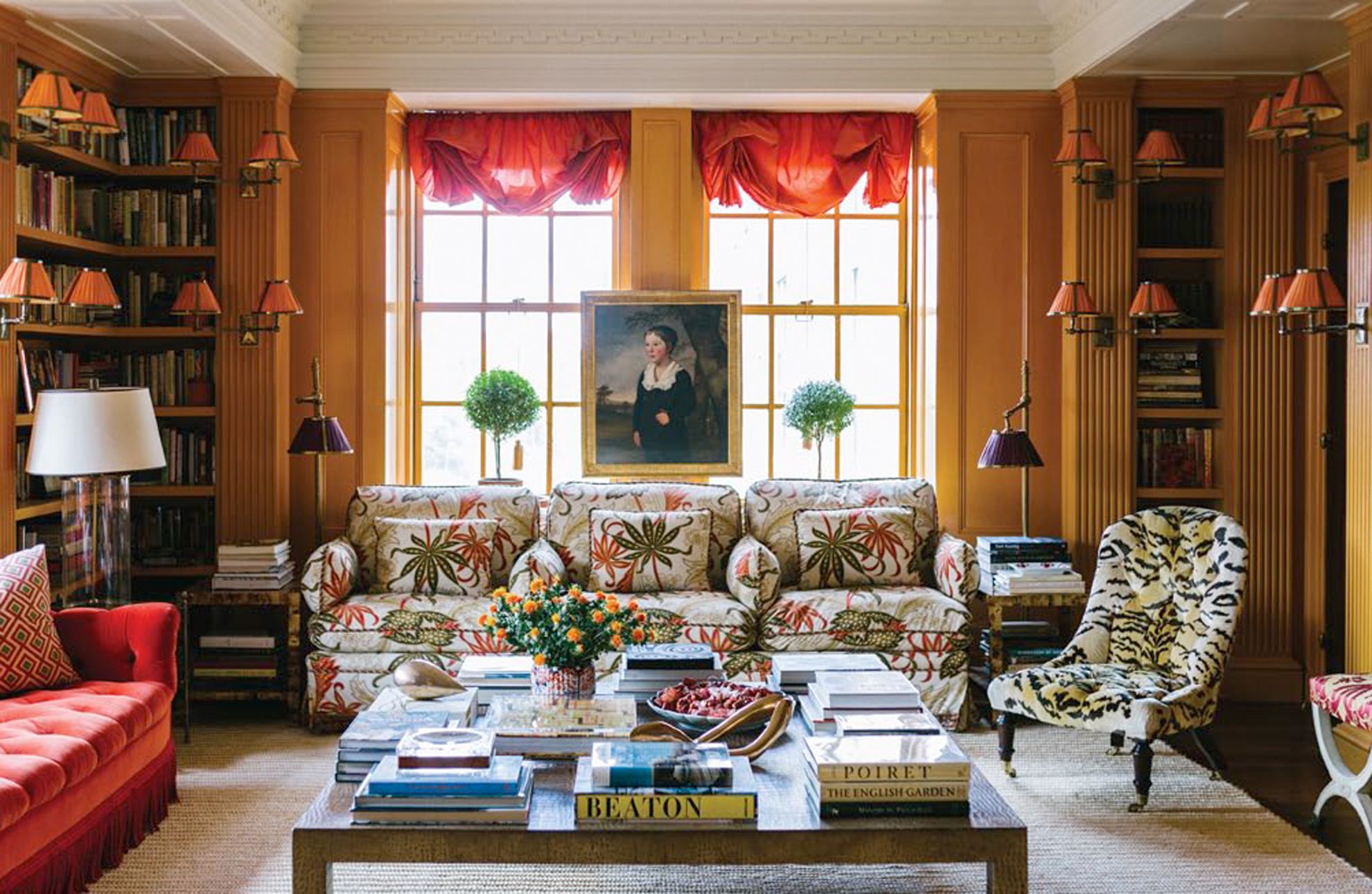 tory-burch-new-york-apartment-home-red-sofa -orange-room-coffee-table-bookshelves-tiger-velvet-chair-library-tatler