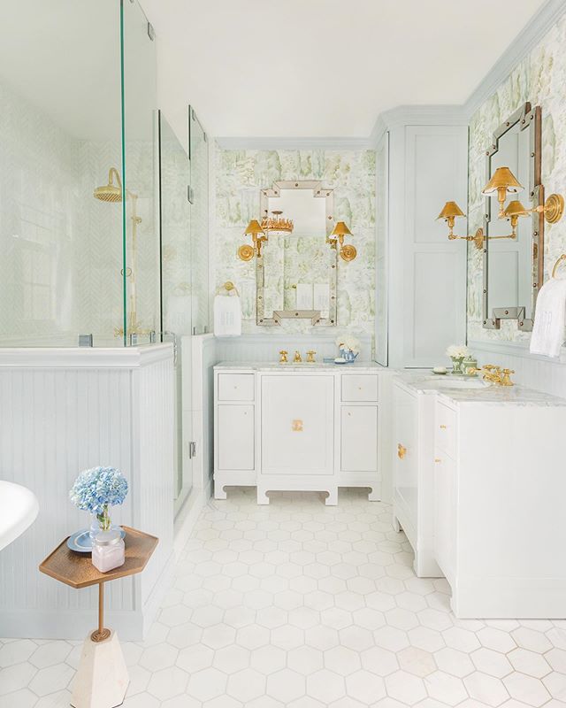 Bathroom with blue wainscoting and green scenic Sanderson wallpaper, monogrammed Weezie towels, and a Colefax and Fowler Bowood print chair by Tori Alexander of Alexander Interiors in Nashville.