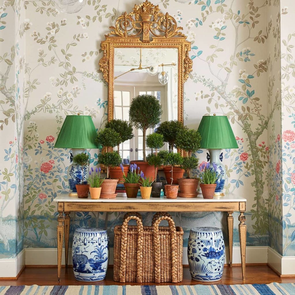 Topiaries and chinoiserie wallpaper console table styling with blue and white garden stools Caroline Gidiere interior design
