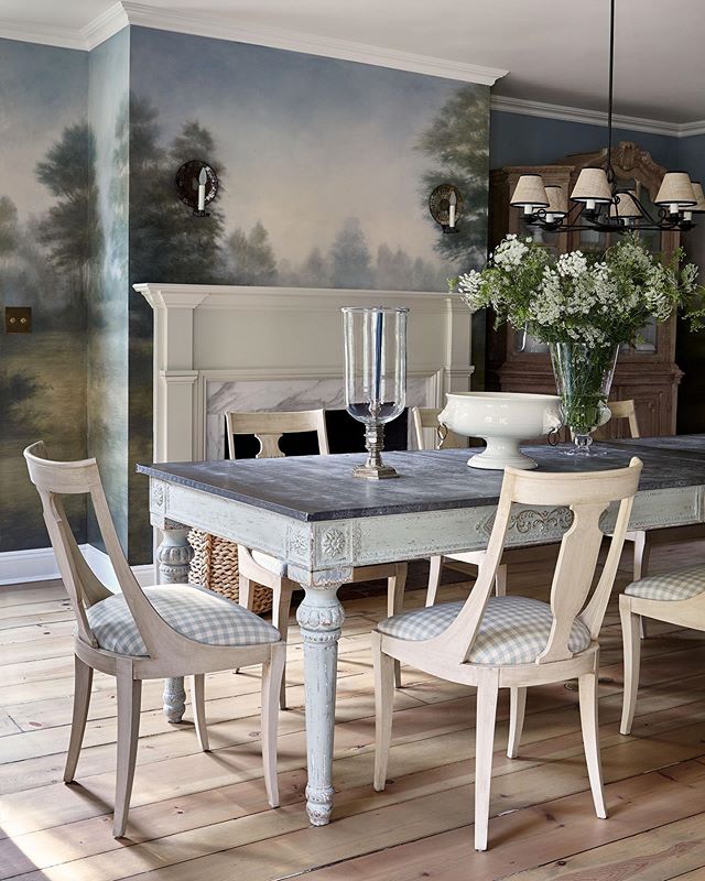 Dining room with landscape mural and Swedish gingham dining chairs decorated by McGrath II.